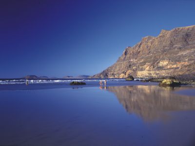 An der Playa de Famara, mit sechs Kilometern Lanzarotes längster Strand, fühlen sich vor allem Kiter und Surfer wohl.