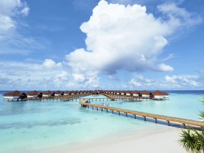 Die Wasser-Bungalow-Anlage des ROBINSON Club Maldives/Malediven. Drumherum nur türkisblaues Meer, kleine Inseln, Korallen, und traumhaftes Wetter.