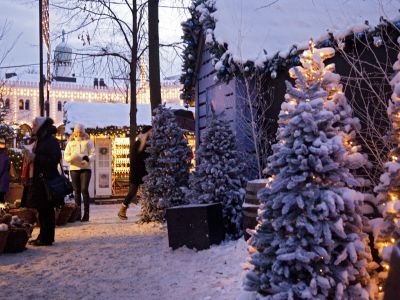 Weihnachtsmarkt in Tivoli mit schneebedeckten Tannen.