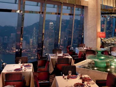 Restaurant mit Blick auf die Stadt und den Hafen am Abend im The Ritz-Carlton, Hong Kong.